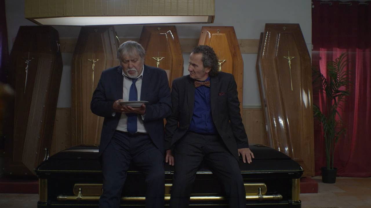 Due famiglie, un funerale backdrop