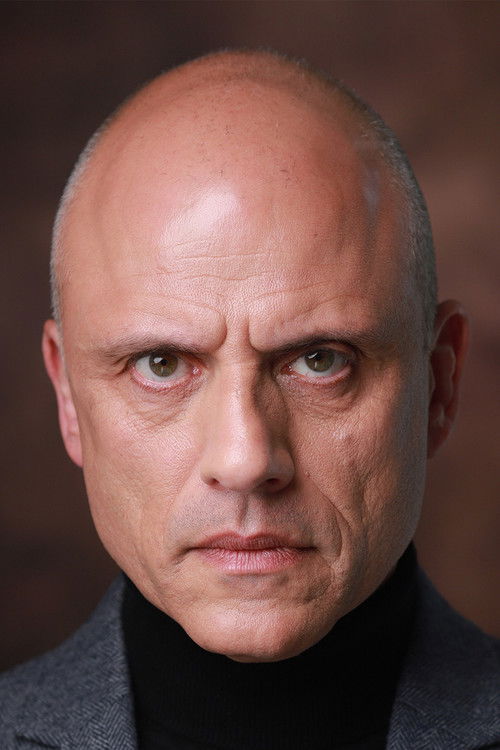 Mike Mousicos as John Adamos