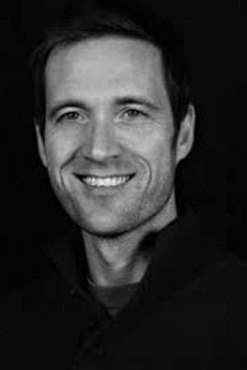 Nathan Roach as Police Booking Officer